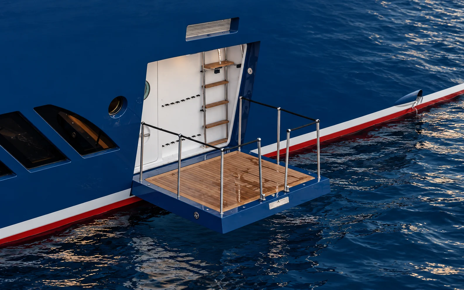 Open hull door folded down into a teak platform at the waterline, with steps leading up inside